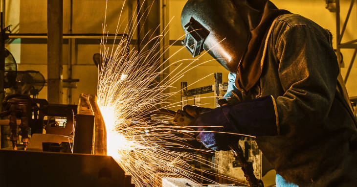 A welder is protected from sparks by wearing a FR welding shirt and jacket.