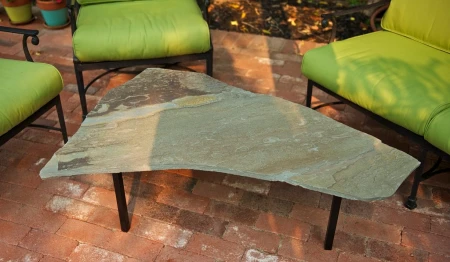 Cut stone coffee table with welded metal legs.